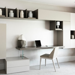 Inspiration för ett funkis hemmabibliotek, med beige väggar, ett inbyggt skrivbord och beiget golv