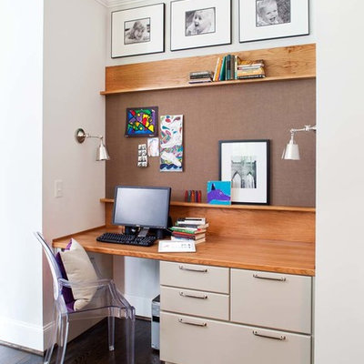 Trendy built-in desk dark wood floor home office photo in Atlanta with white walls