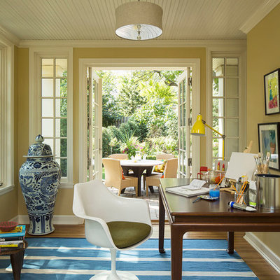 Home office - eclectic freestanding desk dark wood floor home office idea in Minneapolis with yellow walls