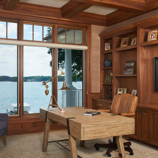 Maritim inredning av ett arbetsrum, med ett bibliotek, beige väggar, ett fristående skrivbord och beiget golv