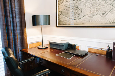 Mid-sized elegant freestanding desk dark wood floor home office photo in Calgary with beige walls