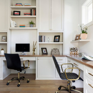 Mittelgroßes Maritimes Arbeitszimmer mit weißer Wandfarbe, braunem Holzboden, Einbau-Schreibtisch, Arbeitsplatz und braunem Boden in Minneapolis