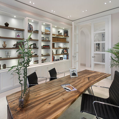 Example of a tuscan freestanding desk home office design in Miami with gray walls