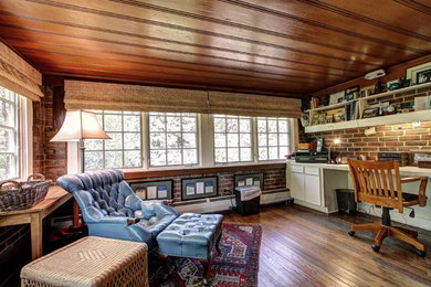 デンバーにあるお手頃価格の広いカントリー風のおしゃれな書斎 (濃色無垢フローリング、暖炉なし、造り付け机、茶色い床、赤い壁) の写真