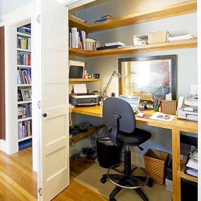 Elegant built-in desk medium tone wood floor home office photo in San Francisco with gray walls