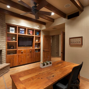 Aménagement d'un grand bureau classique avec un mur beige, un bureau indépendant, béton au sol, une cheminée d'angle et un manteau de cheminée en brique.
