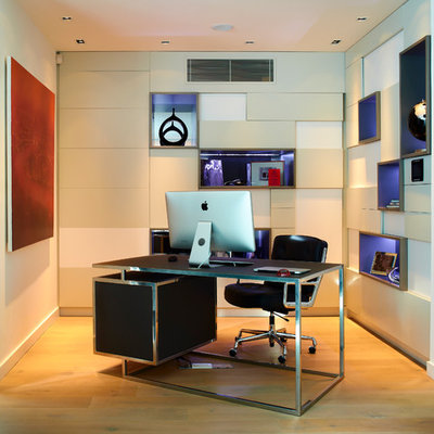 Example of a mid-sized trendy freestanding desk light wood floor study room design in London with beige walls