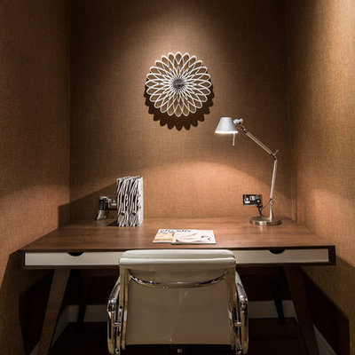 Example of a small trendy built-in desk study room design in London with brown walls