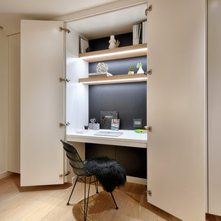Inspiration for a small contemporary built-in desk light wood floor and beige floor study room remodel in San Diego with black walls