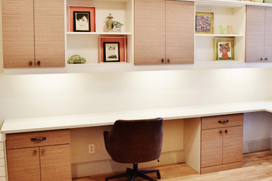 Study room - large contemporary built-in desk light wood floor study room idea in Dallas with white walls and no fireplace