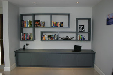 Ejemplo de despacho contemporáneo pequeño con paredes grises, suelo de piedra caliza y escritorio empotrado