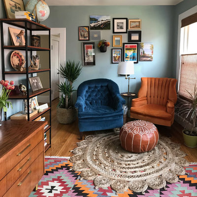 Mid-sized eclectic medium tone wood floor and brown floor home office library photo in Boston with blue walls