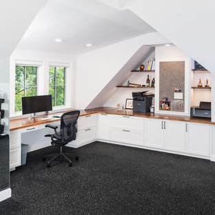 Großes Klassisches Arbeitszimmer ohne Kamin mit Arbeitsplatz, weißer Wandfarbe, Vinylboden, Einbau-Schreibtisch und schwarzem Boden in Boston