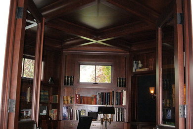 Imagen de despacho clásico con suelo de madera oscura y escritorio independiente