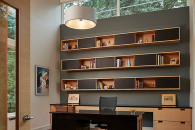 Foto de despacho actual grande con paredes grises, suelo de madera oscura y escritorio independiente
