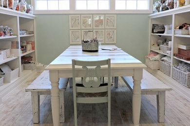 Imagen de sala de manualidades costera de tamaño medio sin chimenea con paredes azules, suelo vinílico y escritorio independiente