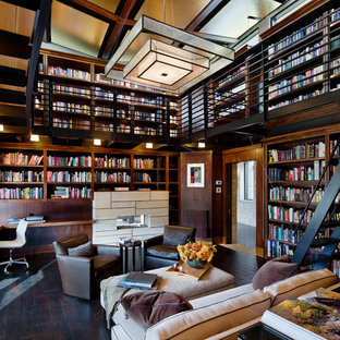 Idee per un ampio studio minimal con parquet scuro, scrivania incassata, pavimento nero, libreria, pareti marroni, camino lineare Ribbon e cornice del camino piastrellata