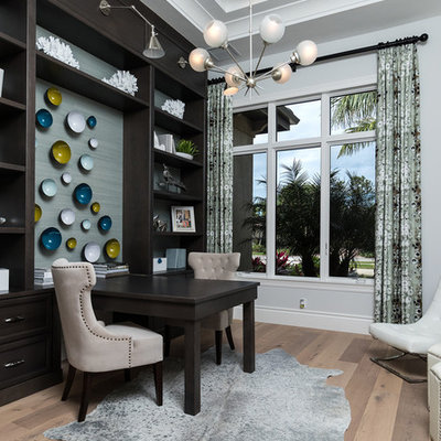 Example of a mid-sized tuscan built-in desk light wood floor and beige floor study room design in Other with gray walls and no fireplace