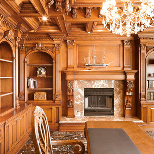 Idee per un ampio studio classico con scrivania incassata, libreria, pareti gialle, pavimento con piastrelle in ceramica, cornice del camino in legno e pavimento marrone