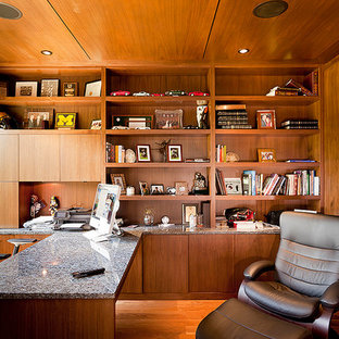 Cette image montre un bureau design de taille moyenne avec un mur marron, un sol en bois brun, une cheminée ribbon et un bureau intégré.