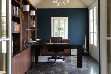 Imagen de despacho contemporáneo con paredes azules y escritorio empotrado