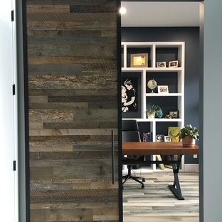 Esempio di un grande studio moderno con libreria, pareti blu, pavimento con piastrelle in ceramica, scrivania autoportante e pavimento grigio