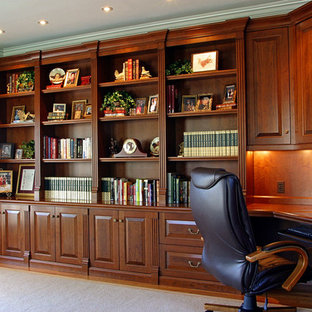 Idéer för att renovera ett stort vintage hemmabibliotek, med beige väggar, ljust trägolv och ett inbyggt skrivbord