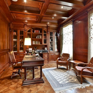 Großes Klassisches Arbeitszimmer ohne Kamin mit brauner Wandfarbe, braunem Holzboden, freistehendem Schreibtisch, braunem Boden und Arbeitsplatz in Toronto