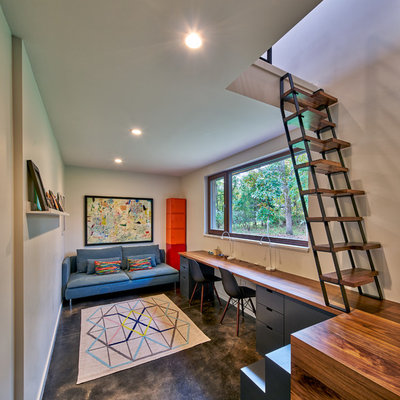 Trendy built-in desk concrete floor and gray floor home office photo in Grand Rapids with gray walls