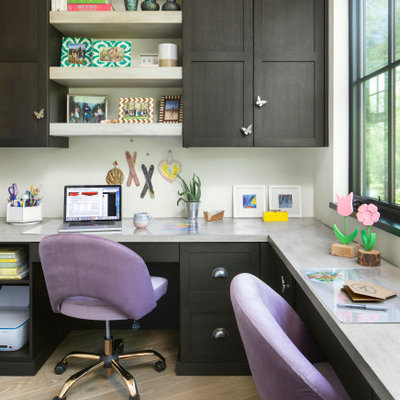 Home office - country built-in desk light wood floor and beige floor home office idea in Denver with white walls