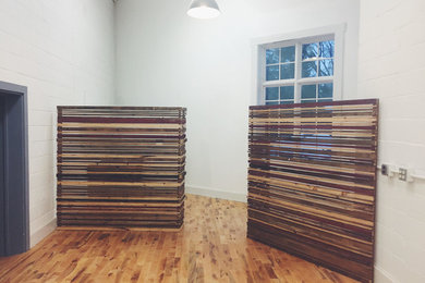 Ejemplo de estudio rústico de tamaño medio con paredes blancas, suelo de madera en tonos medios y suelo marrón