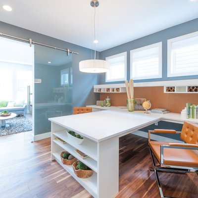 Inspiration for a mid-sized contemporary built-in desk medium tone wood floor and brown floor craft room remodel in Calgary with gray walls
