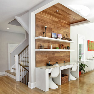 Modernes Arbeitszimmer mit Arbeitsplatz, braunem Holzboden und Einbau-Schreibtisch in New York
