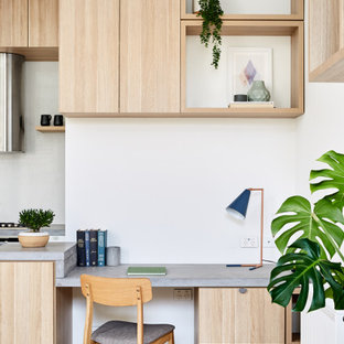 Small contemporary home office in Melbourne with white walls, light hardwood floors and brown floor.