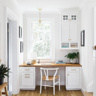 Study room - small traditional built-in desk light wood floor study room idea in Boston with white walls