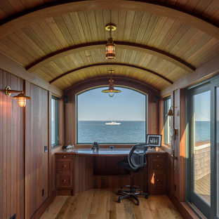 Example of a small beach style built-in desk medium tone wood floor and brown floor study room design in Boston with brown walls and no fireplace