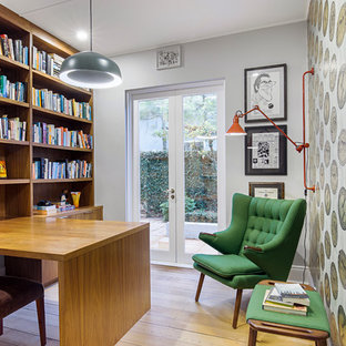 This is an example of an eclectic study room in Sydney with grey walls, light hardwood floors, a built-in desk and beige floor.