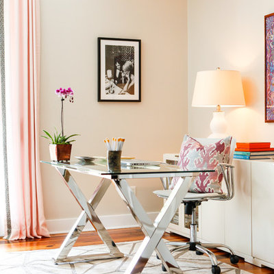 Study room - large eclectic freestanding desk medium tone wood floor study room idea in Houston with beige walls
