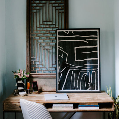 Eclectic freestanding desk dark wood floor and brown floor home office photo in Columbus with blue walls