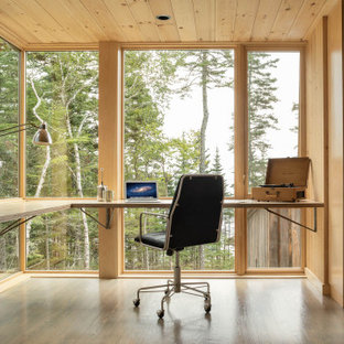 Mittelgroßes Rustikales Arbeitszimmer ohne Kamin mit brauner Wandfarbe, braunem Holzboden, Einbau-Schreibtisch, grauem Boden und Arbeitsplatz in Portland Maine