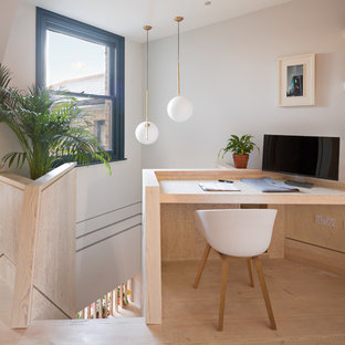 Idéer för att renovera ett mellanstort funkis arbetsrum, med flerfärgade väggar, plywoodgolv, ett inbyggt skrivbord och brunt golv