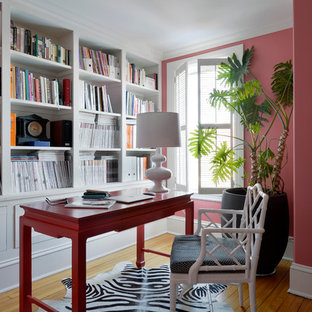 Inredning av ett klassiskt stort arbetsrum, med rosa väggar, ljust trägolv, ett fristående skrivbord och ett bibliotek