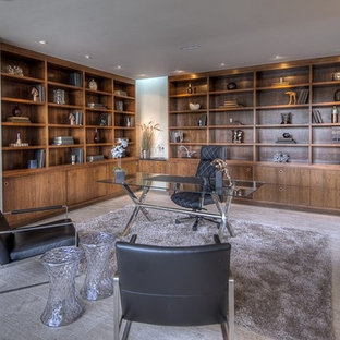 Modern inredning av ett stort arbetsrum, med beige väggar, kalkstensgolv och ett fristående skrivbord