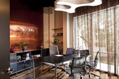 オーランドにあるコンテンポラリースタイルのおしゃれなホームオフィス・書斎 (濃色無垢フローリング、自立型机、茶色い床) の写真