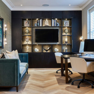 Design ideas for a classic study in London with grey walls, medium hardwood flooring, no fireplace, a built-in desk and brown floors.
