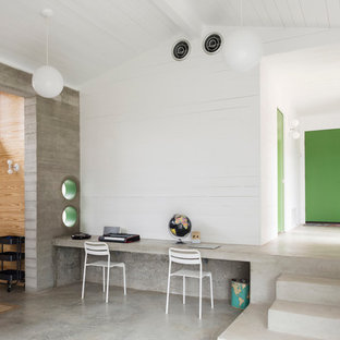 Foto di un atelier design di medie dimensioni con pareti bianche, pavimento in cemento, nessun camino, scrivania incassata e pavimento grigio