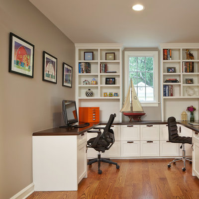 Home office - mid-sized traditional built-in desk medium tone wood floor and brown floor home office idea in Chicago with beige walls and no fireplace