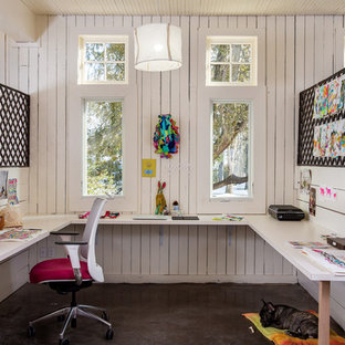 Example of a large minimalist built-in desk concrete floor and gray floor craft room design in Boston with white walls