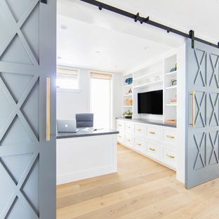 Mittelgroßes Landhausstil Arbeitszimmer mit weißer Wandfarbe, braunem Holzboden, Einbau-Schreibtisch und beigem Boden in Orange County