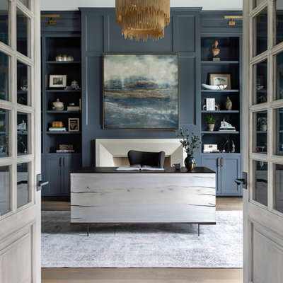 Inspiration for a huge transitional freestanding desk medium tone wood floor study room remodel in Houston with blue walls, a standard fireplace and a stone fireplace